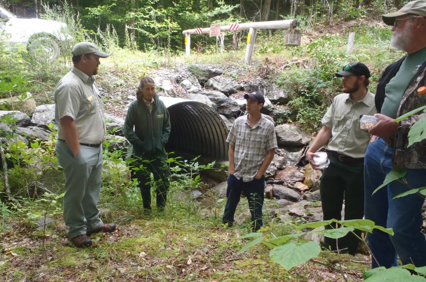Natural resource professionals standing at the outlet of a large culvert