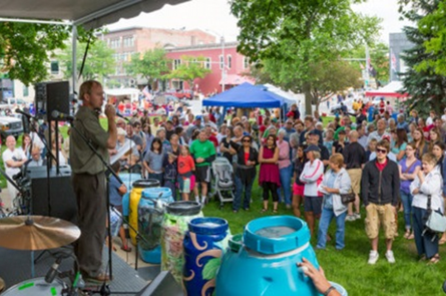 people gathered at an outdoor event for arbor day with a stage. 